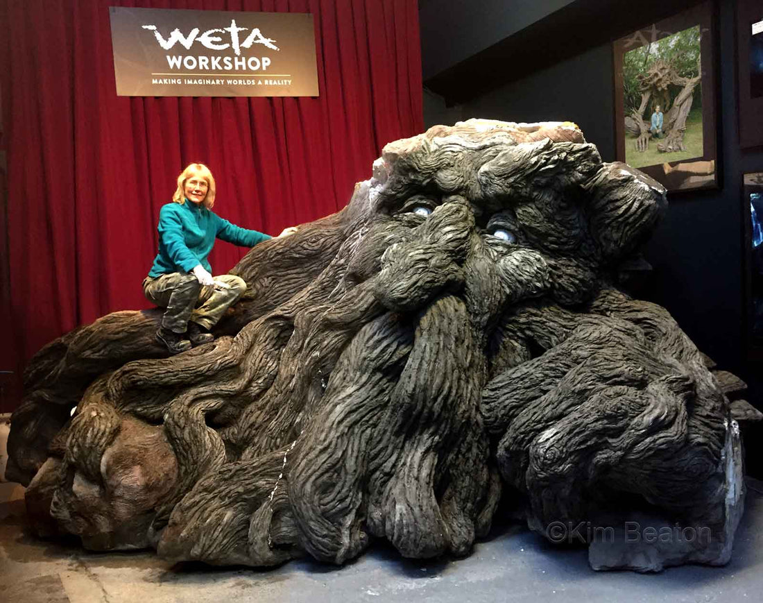 Kim Beaton sitting a top of one of her large tree troll sculptures at Weta Workshop in New Zealand