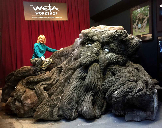 Kim Beaton sitting a top of one of her large tree troll sculptures at Weta Workshop in New Zealand