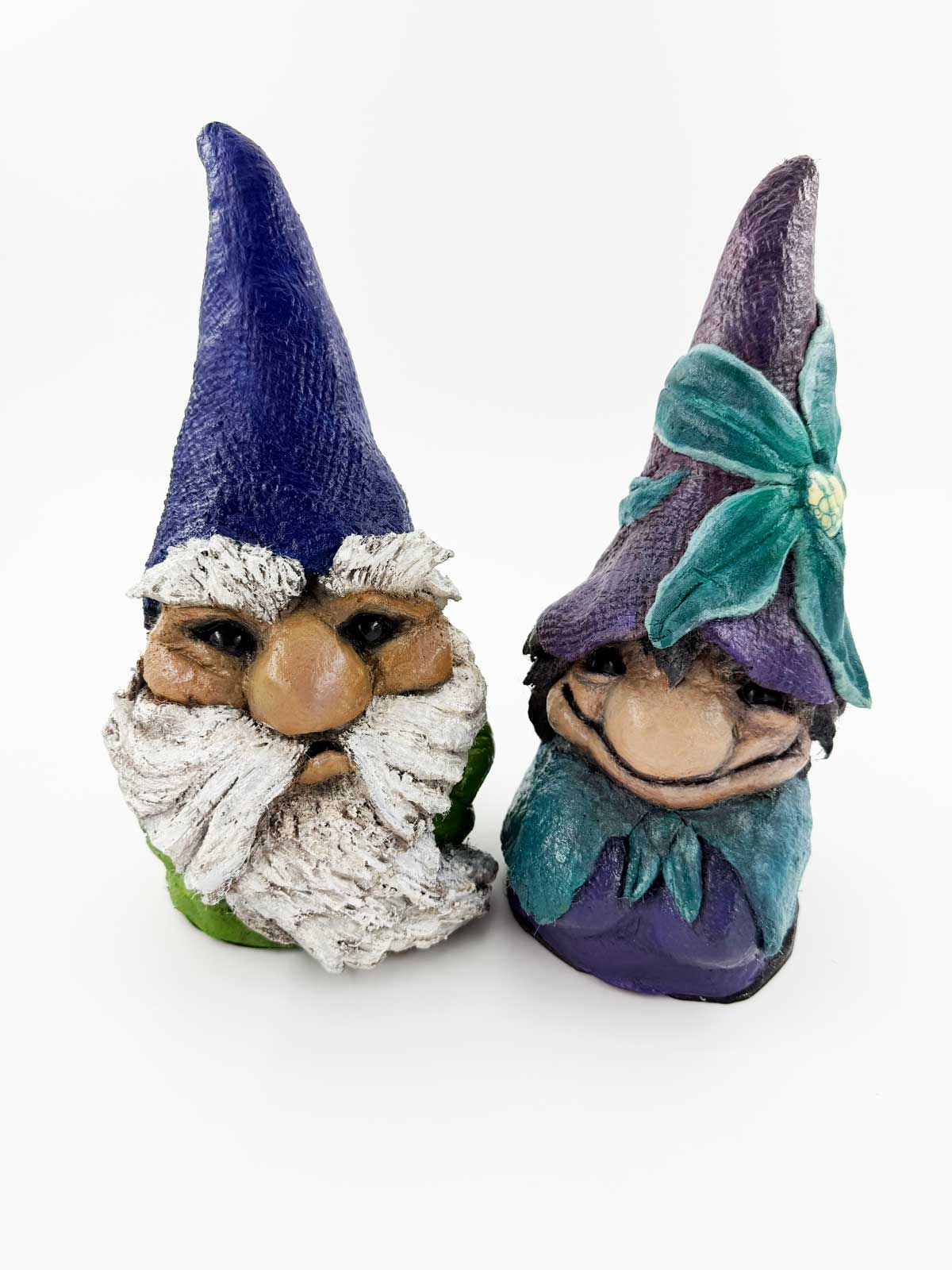 Two garden gnome figurines with colorful hats made with Pal Tiya Premium on a white background