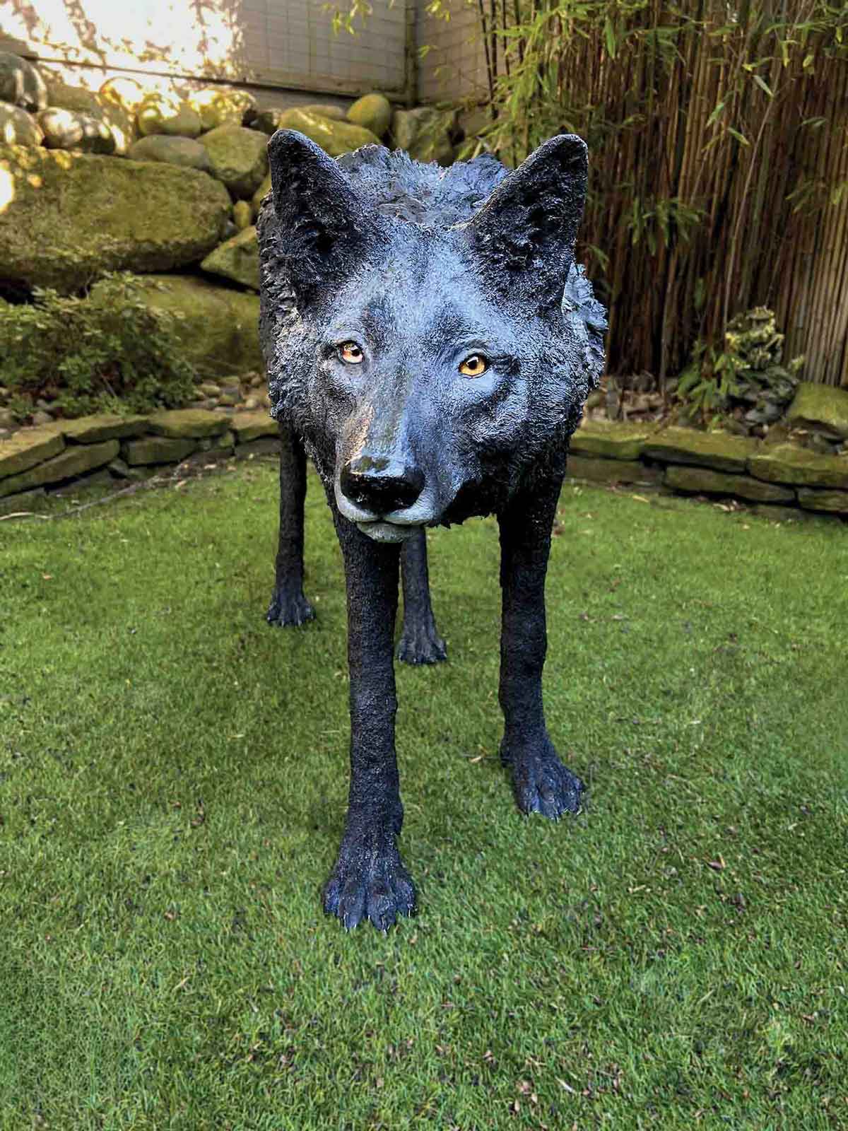 Pal Tiya Premium Statue of a Timber wolf on grass with a garden background